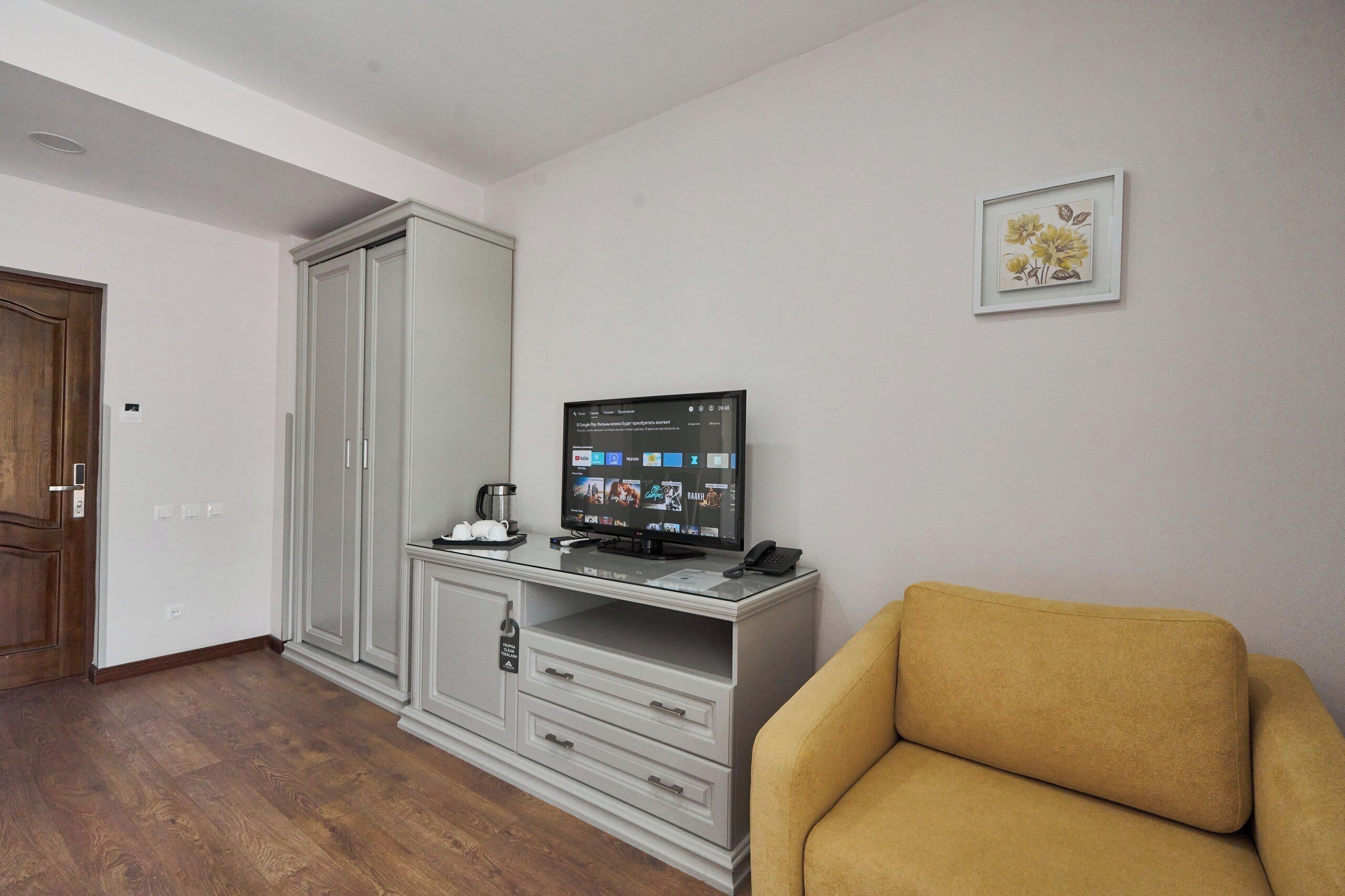 A living room with a television, a sofa, a cabinet, and a door.