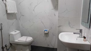 Une salle de bain avec des toilettes, un lavabo et un miroir.