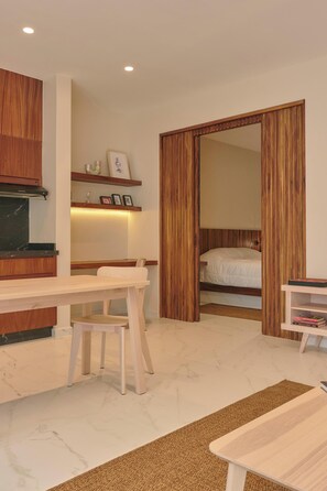 A bedroom with a bed, wooden wardrobe, a desk with a chair, and a small shelf with items. - Unique Apartment w/ Pool Access in MU Kuadru (Oaxaca de Juárez)
