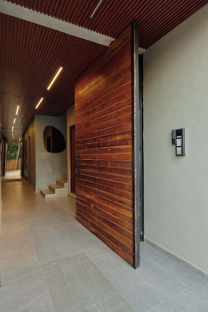 A modern hallway with wooden paneling, a staircase, and a wall-mounted intercom. - Unique Apartment w/ Pool Access in MU Kuadru (Oaxaca de Juárez)