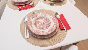 A table set with plates, cutlery, and a glass.