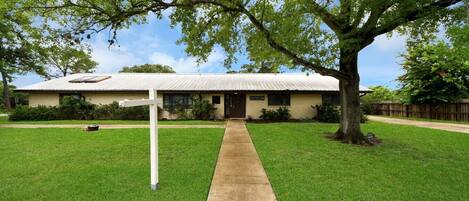 A single-story house with a sloped roof, a front porch, and a well-maintained lawn.
