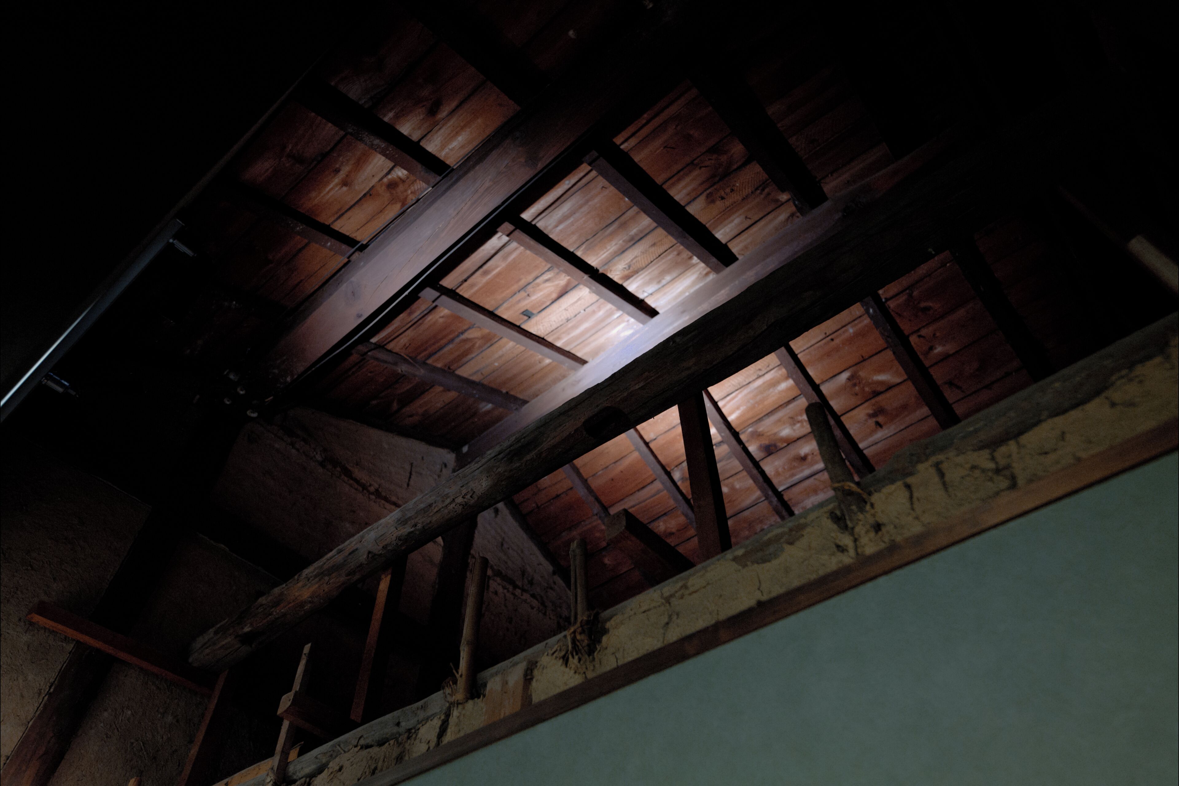 A wooden ceiling with exposed beams and a skylight.