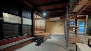 Ein traditioneller japanischer Raum mit Tatami-Bodenbelag, einer niedrigen Holzbank und einer Schiebetür mit Shoji-Schirm.
