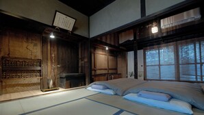 Ein traditioneller japanischer Raum mit Tatami-Boden, einem niedrigen Holzbett und einem Shoji-Bildschirm.