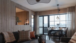 Una sala moderna con un sofá, una mesa redonda y un comedor con sillas.