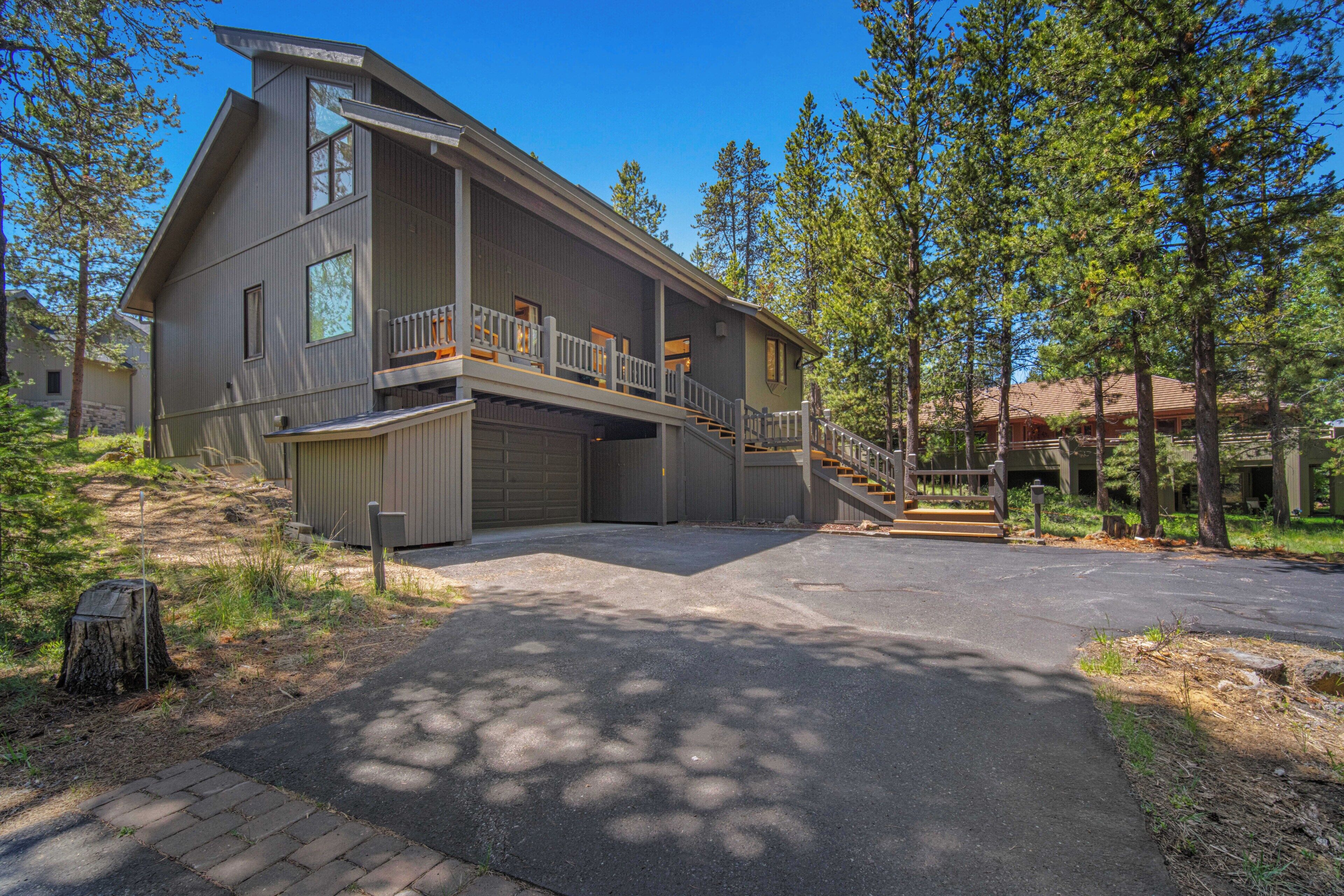 A two-story house with a covered garage, a front porch, and a staircase leading to the upper level.