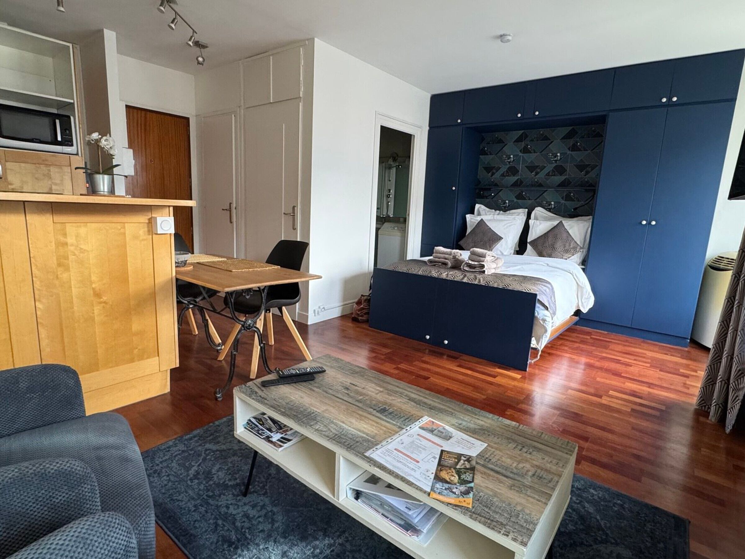 Une chambre moderne avec un grand lit, un bureau en bois et un coin repas.