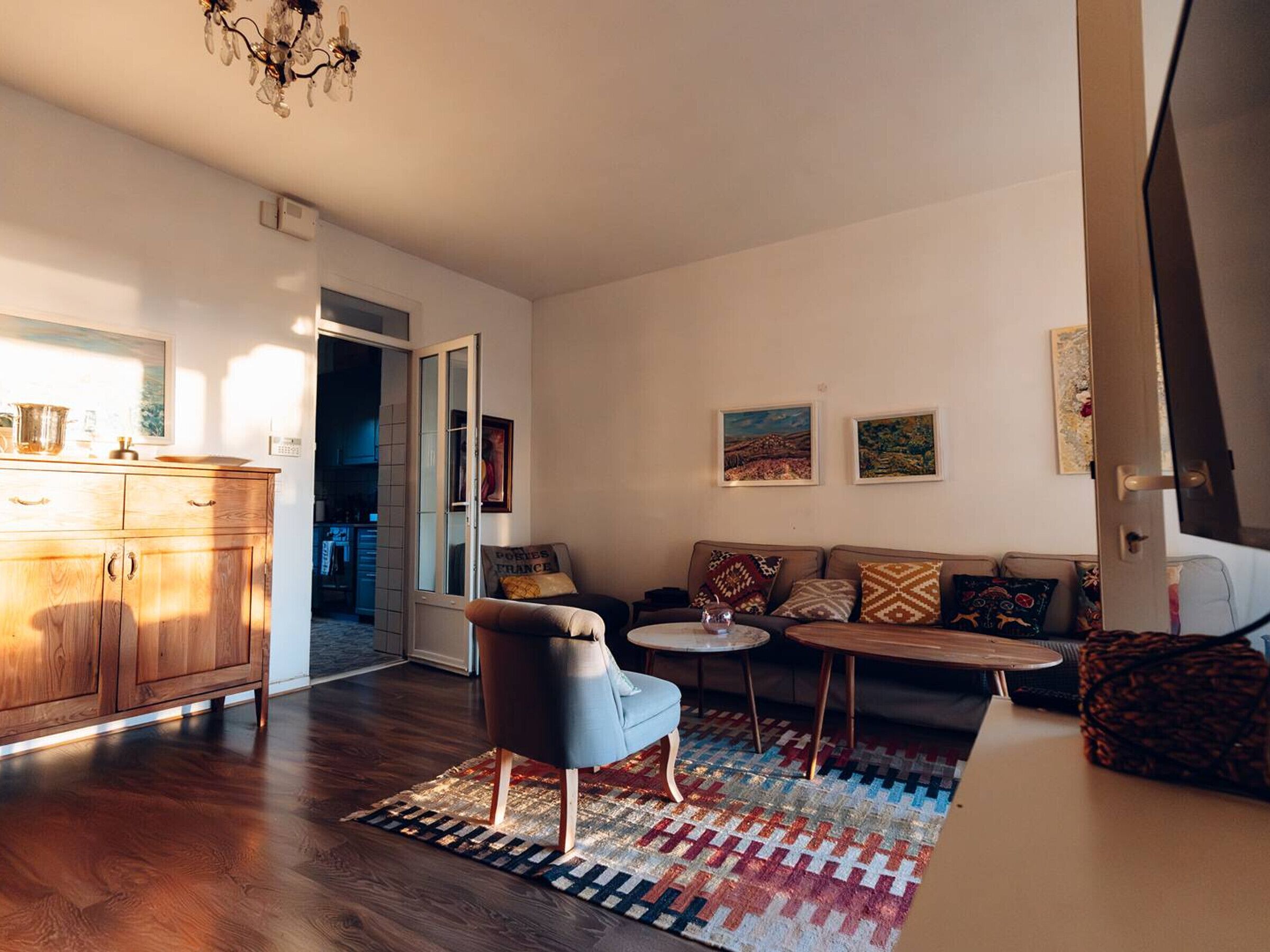 Un salon moderne comprenant un canapé, un fauteuil, une table basse et un meuble en bois.