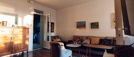 Un salon moderne comprenant un canapé, un fauteuil, une table basse et un meuble en bois.