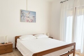 Ein Schlafzimmer mit einem hölzernen Bett, einem Nachttisch, einer Lampe und einem Gemälde an der Wand.