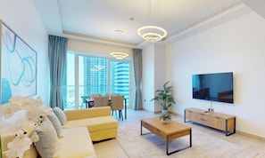 Ein modernes Wohnzimmer mit Sofa, Couchtisch, Fernseher und Essbereich.