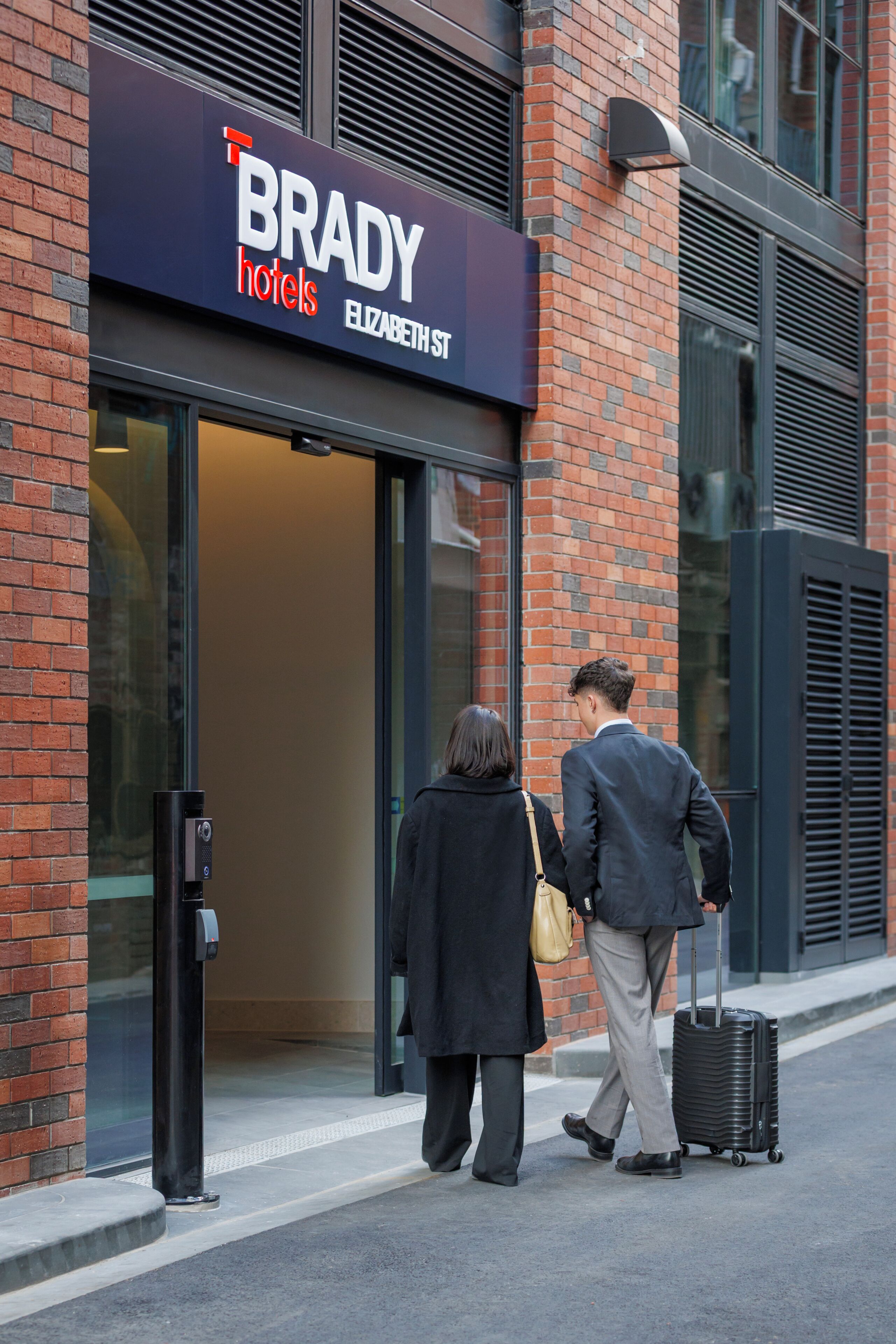 Entrada de un hotel con un letrero que dice 'BRADY hotels' y 'ELIZABETH ST'.