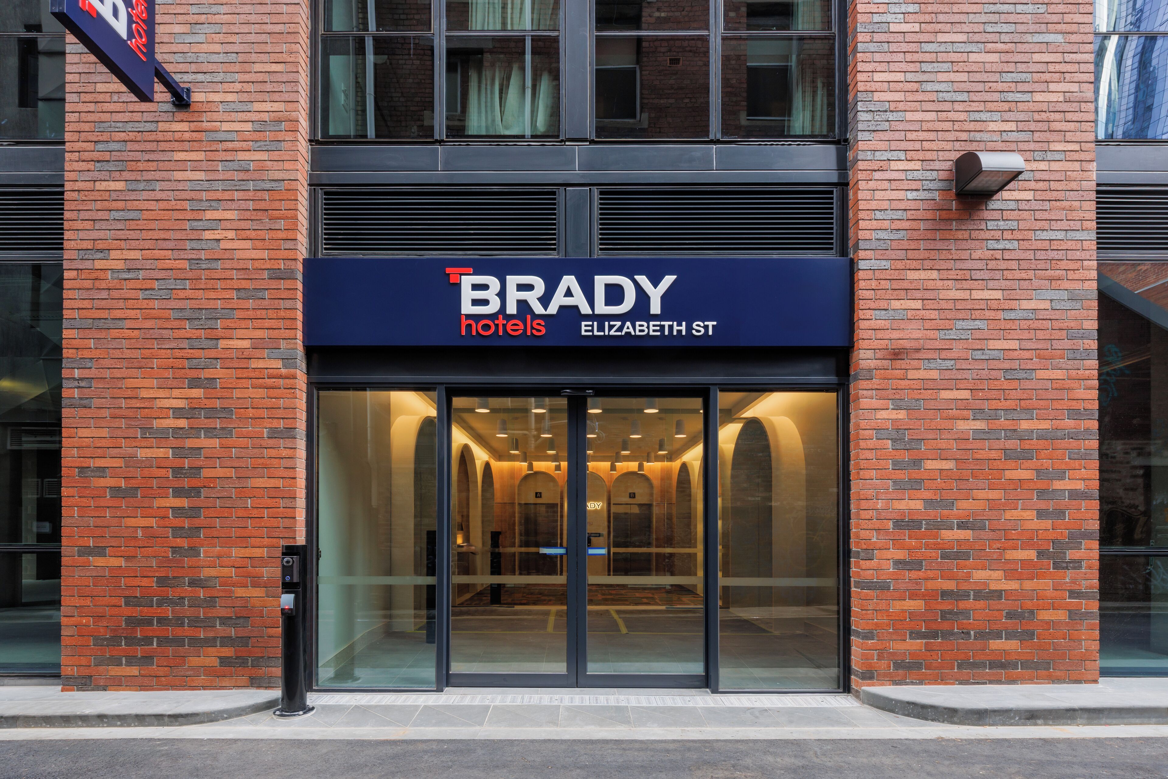 A hotel entrance with a sign reading 'BRADY hotels ELIZABETH ST.'