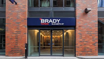 Entrada de hotel con un cartel que dice 'BRADY hotels ELIZABETH ST'.