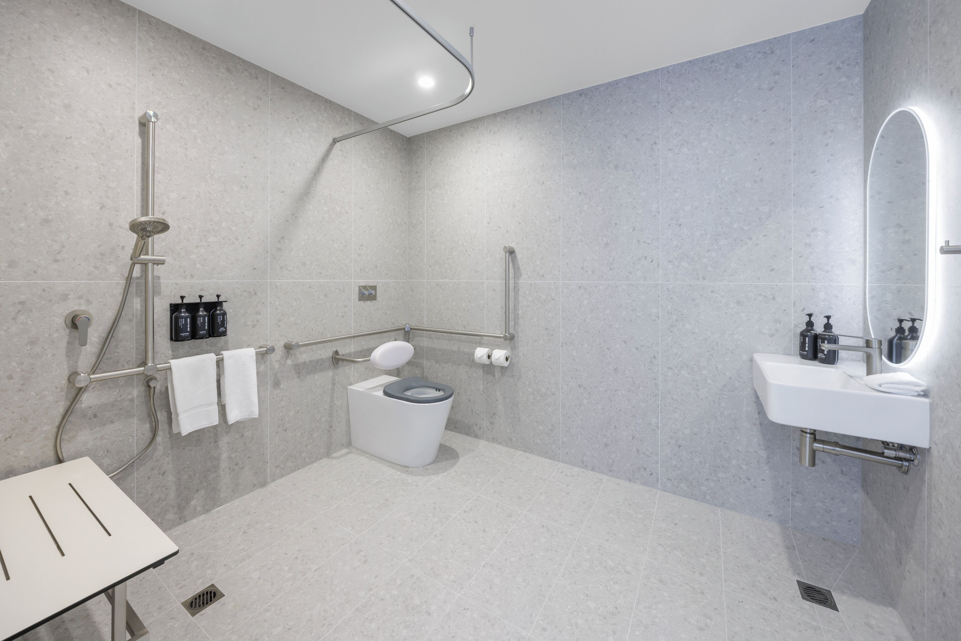 A modern bathroom with a shower, toilet, and sink.