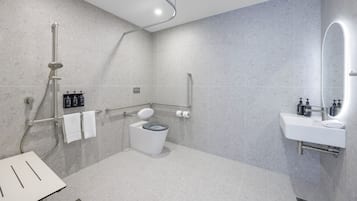 A modern bathroom with a shower, toilet, and sink.