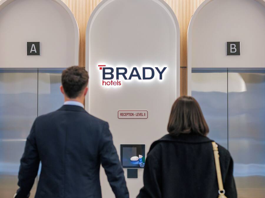 A hotel elevator with a sign indicating 'BRADY hotels' and 'RECEPTION - LEVEL 8'.