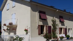 A two-story building with balconies, potted plants, and a gated entrance. - Holiday Home “Gîte Des 4 Lacs Bis” with Mountain View, Private Terrace & Wi-Fi (Vertamboz)