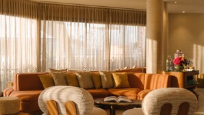 A modern living room with a sectional sofa, a coffee table, and two armchairs. - RIVELIAN Grand Menorca (Ciutadella de Menorca)