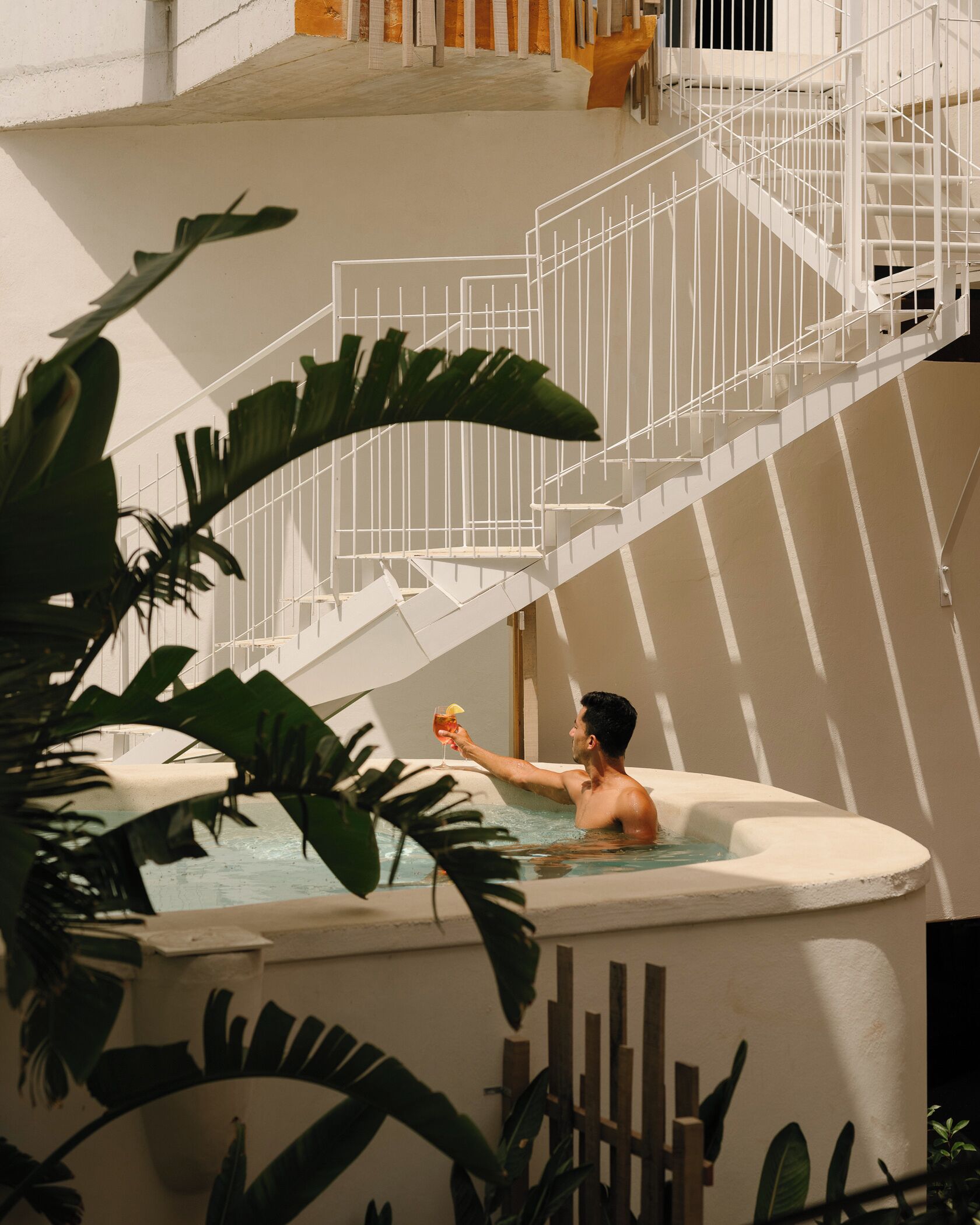 Una persona en un jacuzzi con una escalera al fondo.