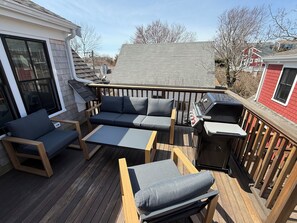 A deck with a sofa, chairs, a table, and a grill. - Modern West End Retreat with 2 King Beds (Provincetown)