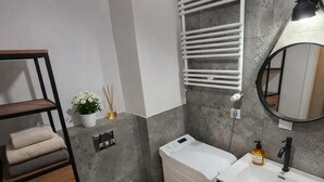 Ein modernes Badezimmer mit Toilette, Waschbecken und Handtuchhalter.
