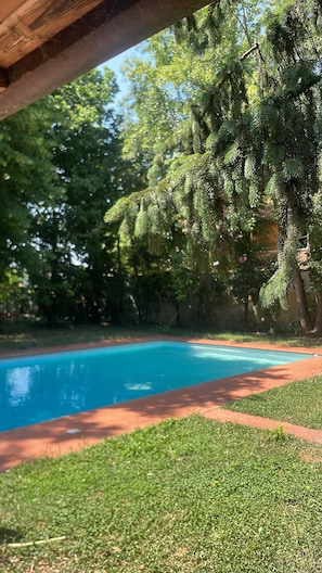 Una piscina circondata da erba e alberi.