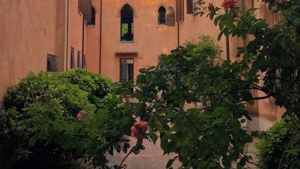 A courtyard with a building featuring arched windows and a tiled roof. - Historic Palazzo with Pool & Castle View (Sanguinetto)