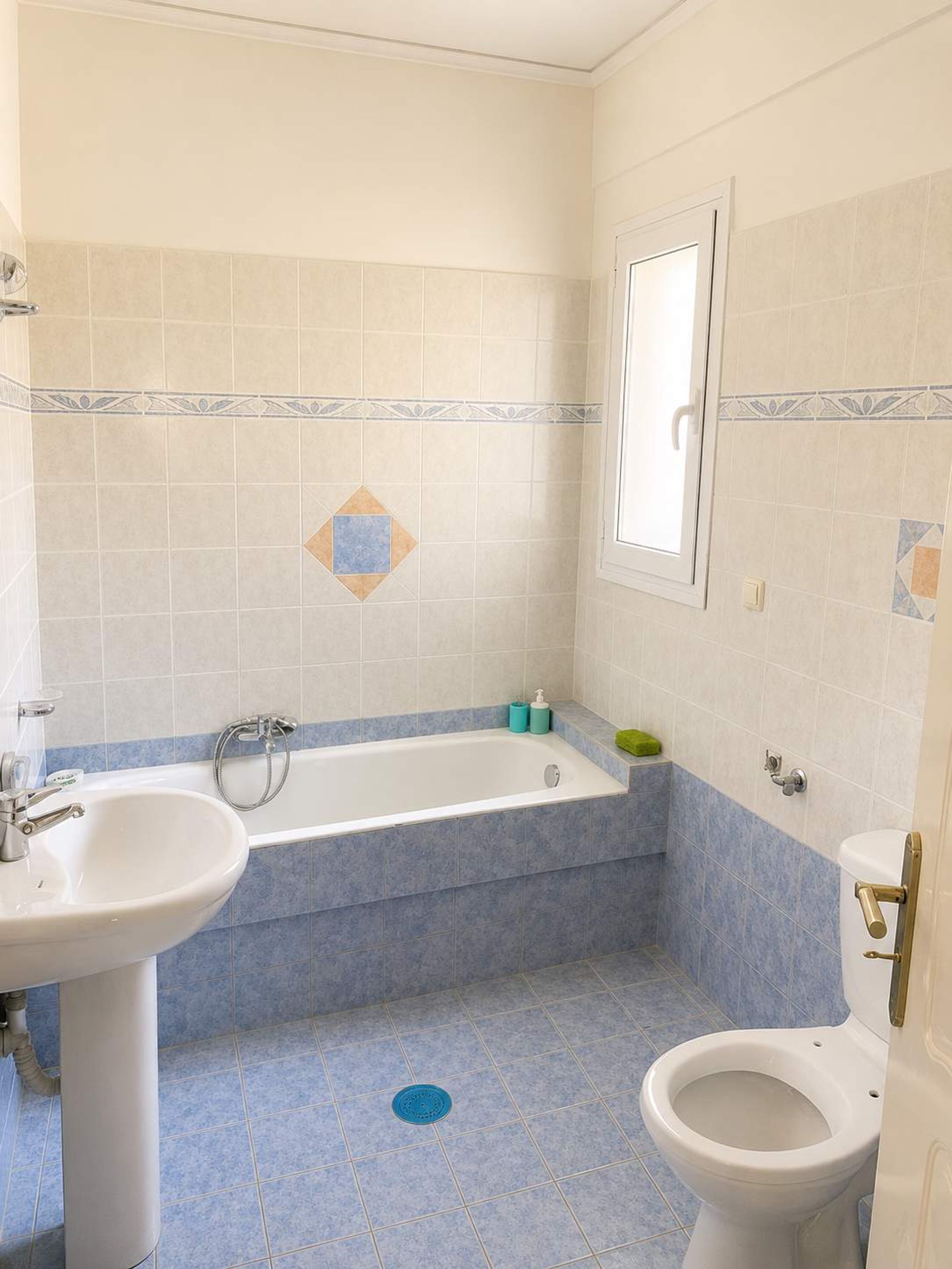 Un bany amb banyera, rentapès, vàter i plat de dutxa.