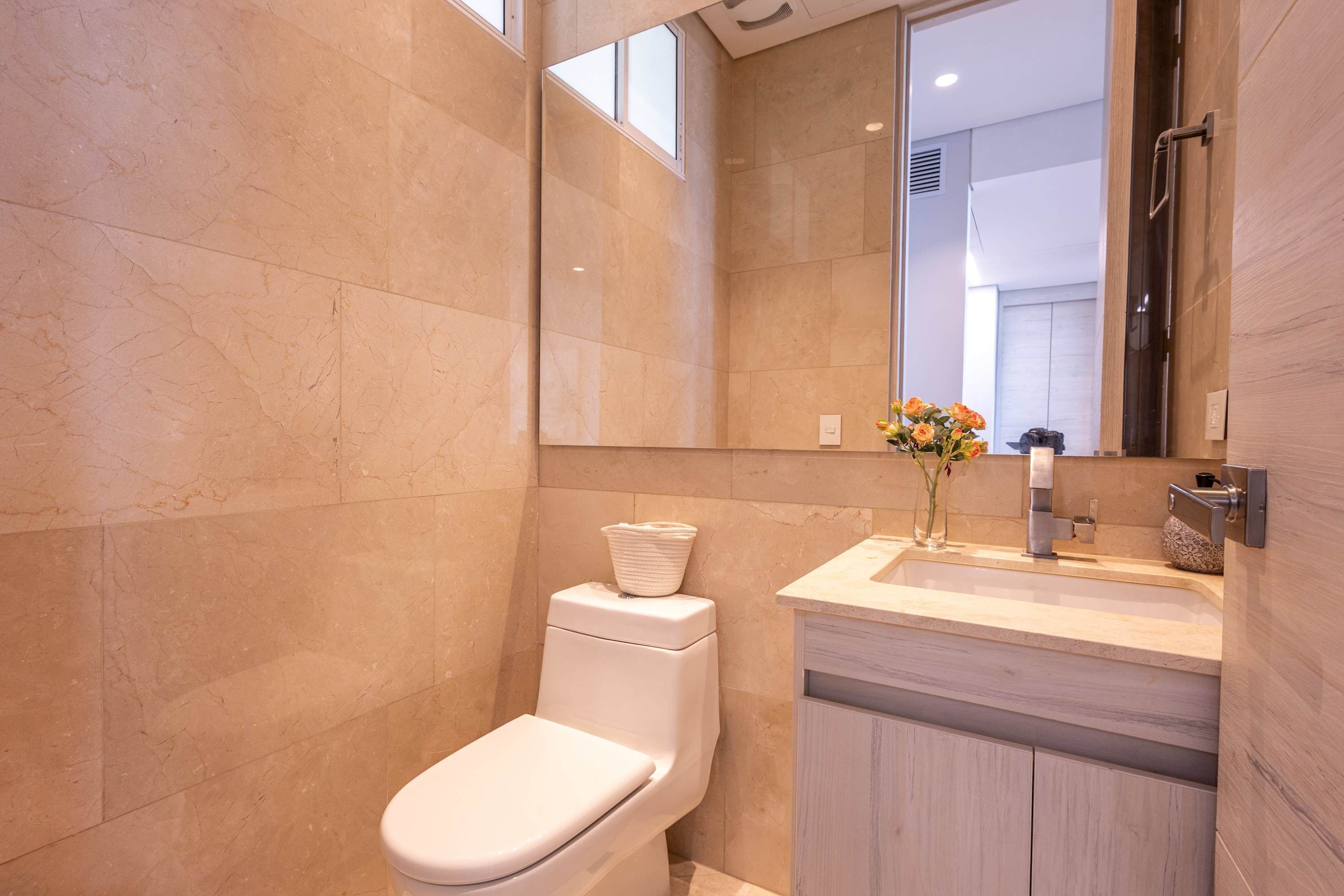 Ein modernes Badezimmer mit Toilette, Waschbecken und Spiegel.