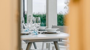 A dining table set with multiple wine glasses, plates, and a menu. - Villa Padana (Piumazzo)