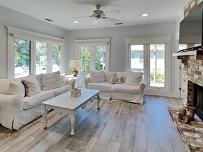 A spacious living room with a white sofa set, a coffee table, and a fireplace. - Tybee Straits 17 | Fantastic Central Location (Tybee Island)