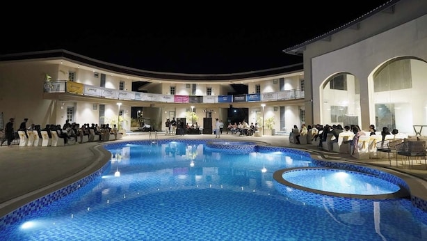 Una amplia piscina interior con suelo de baldosas, rodeada por un edificio de varios niveles con balcones y varios letreros.