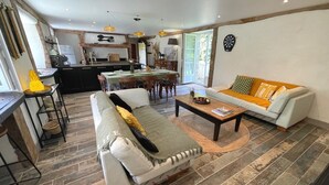 Ein modernes Wohnzimmer mit Sofa, Couchtisch und Essbereich.