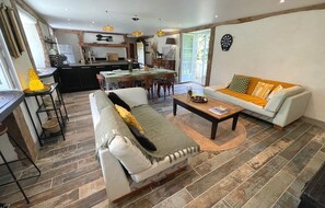 A modern living room with a sofa, coffee table, and dining area. - Newly Renovated Old Mill in Douarnenez (Douarnenez)