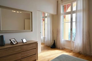 Ein Schlafzimmer mit einem hölzernen Schminktisch, einem großen Spiegel und einem Bett.