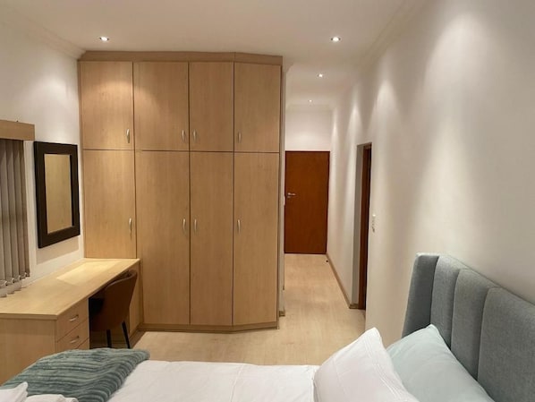 Une chambre à coucher avec un lit, un bureau et une armoire.