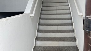 A staircase with white handrails and grey steps leading to an upper floor. - 474flats e Suítes Standart  (Ipatinga)
