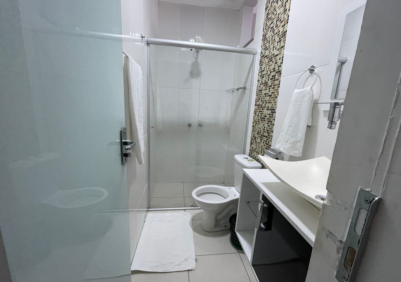 Une salle de bain avec douche, toilettes et lavabo.
