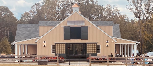A building with a gabled roof, a central entrance, and a porch with columns.