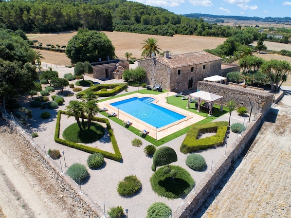 An aerial view of a property with a swimming pool, stone building, and landscaped garden. - Holiday Home 'Finca Son Roig' with Mountain Views, Wi-Fi and Air Conditioning (Sant Joan)