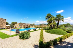 A pool with lounge chairs, a stone building, and palm trees. - Holiday Home 'Finca Son Roig' with Mountain Views, Wi-Fi and Air Conditioning (Sant Joan)
