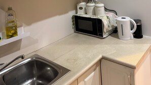 A kitchen with a stainless steel sink, a microwave, a kettle, and a dishwashing liquid bottle. - Separate private room In Sydney region (Hebersham)