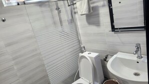 A modern bathroom with a toilet, sink, and shower. - Safe Addis Hotel and Spa (Addis Ababa)