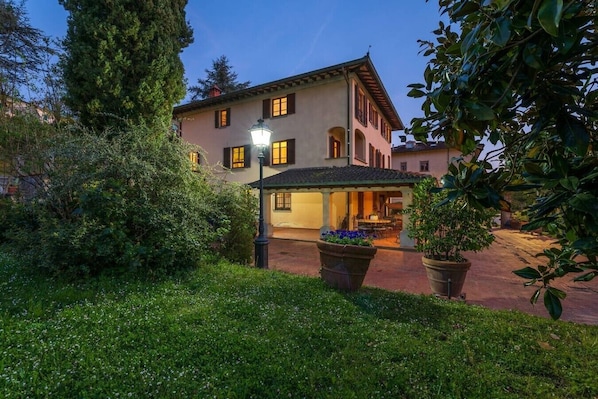 A two-story building with a covered patio and a garden area.
