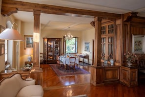 A spacious dining area with a wooden table, chairs, and a chandelier.