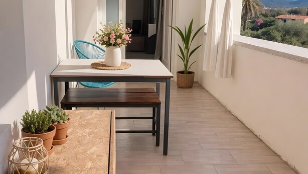A balcony with a table, chairs, potted plants, and a view of the landscape. - Apartment 'Perla' with Sea View, Balcony and Air Conditioning (Agrustos)