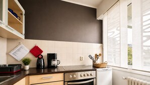 A modern kitchen with a built-in oven, a coffee maker, and a window with a view.