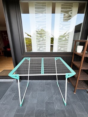A room with a window, a metal drying rack, and a wooden shelf. - Thermen Apartment Bad Rodach 100m to the thermal baths (Bad Rodach)